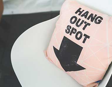 Подушка на кресле с надписью 'Hang Out Spot'